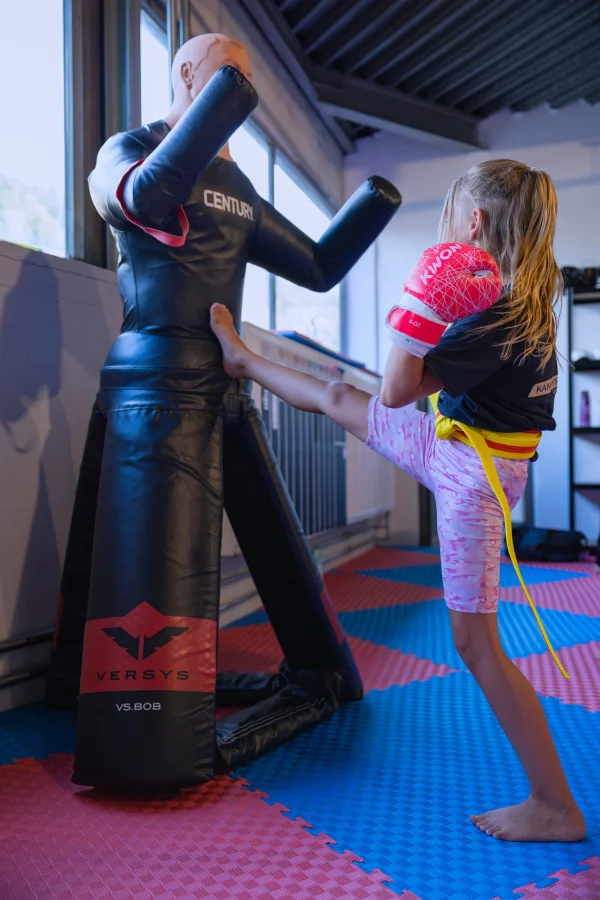 Mädchen kickt gegen den Boxdummy